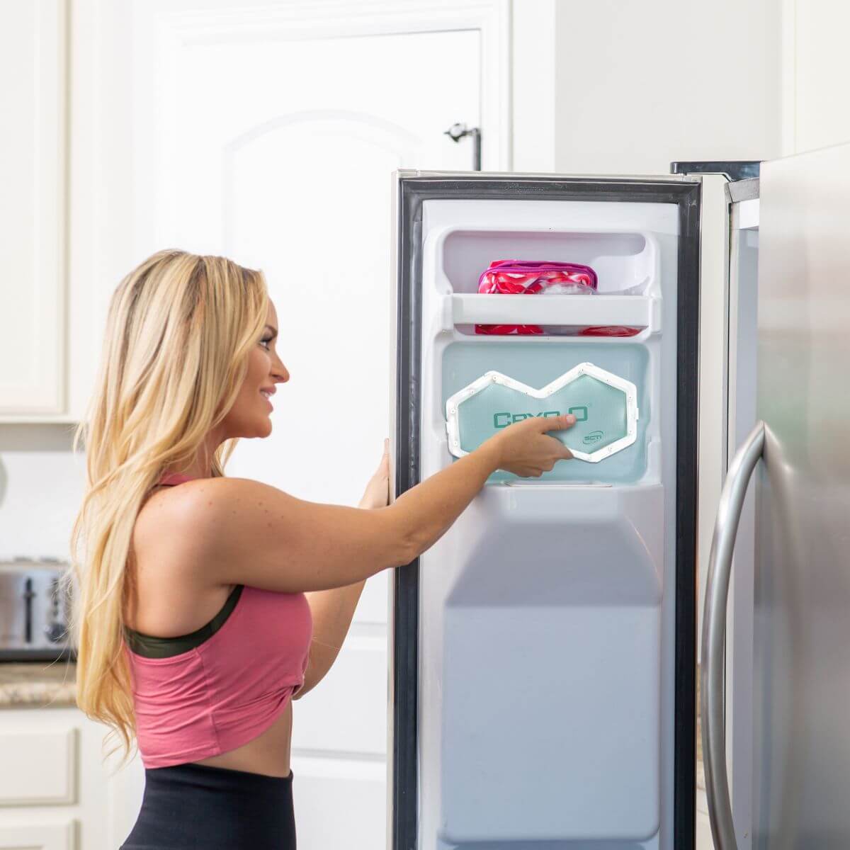 Woman interacting with a smart refrigerator in a kitchen.