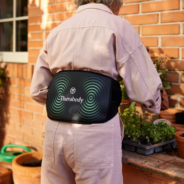 therabody-thermback-LED-back-4in1-multi-modal-synergistic-back-pain-relief-man-student-carrying-books-back-view-rivete-advanced-recovery-and-mobility